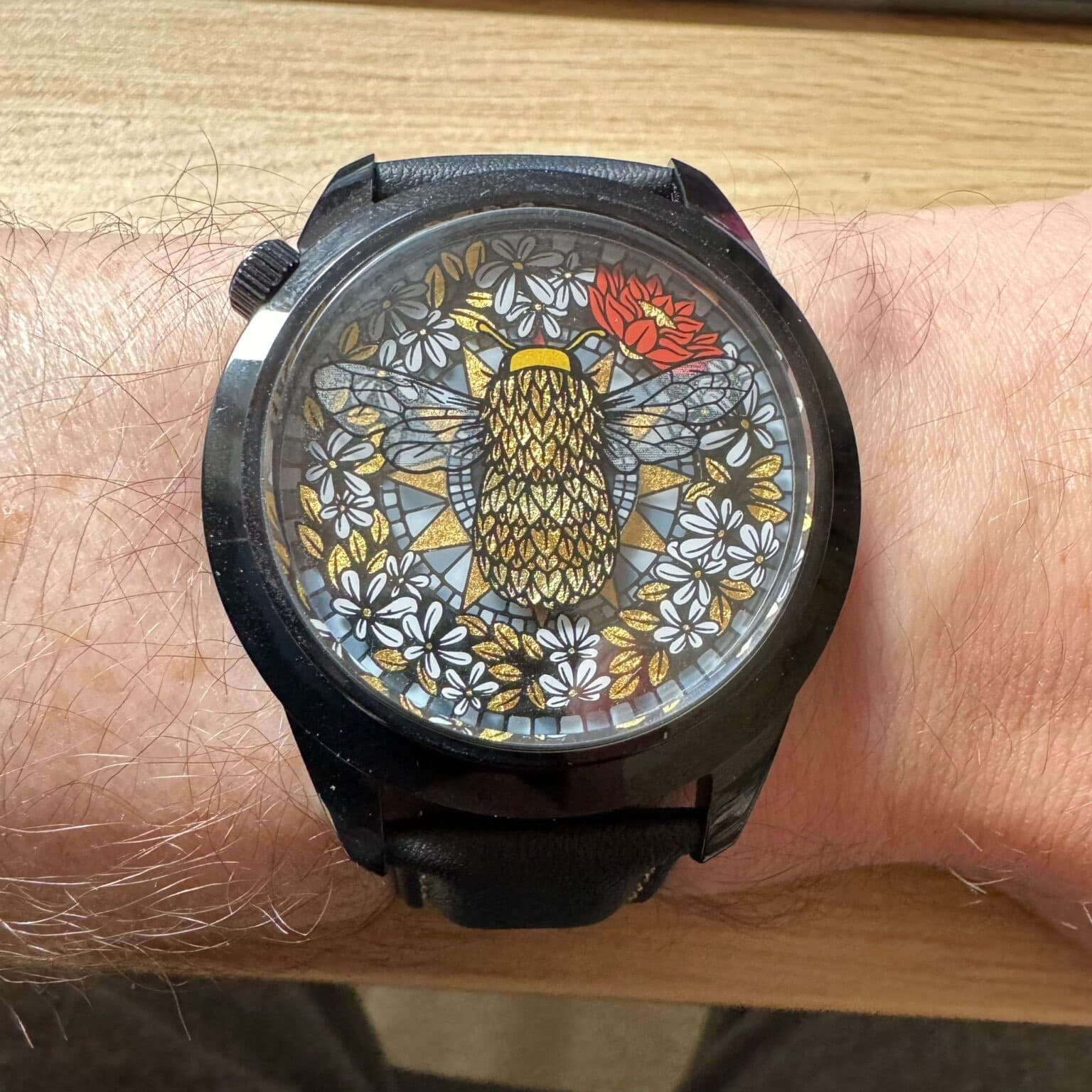 mr. jones watches with bee theme showing a yellow and black bee over a field of flowers all in a black case