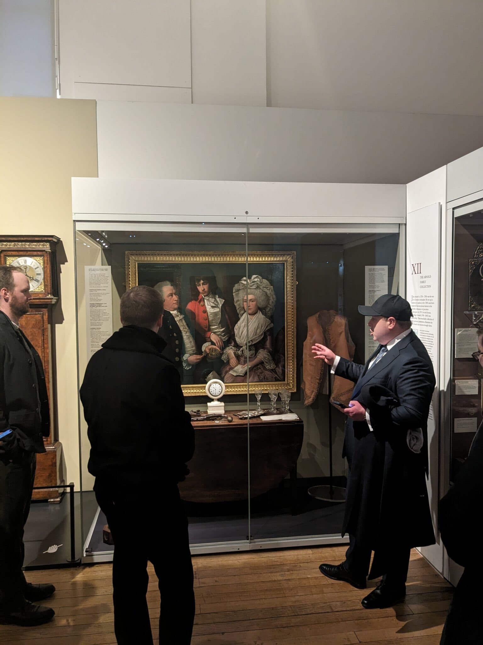 man in dark suit standing in front of painting in museum talking about the history of horology and breguet's role