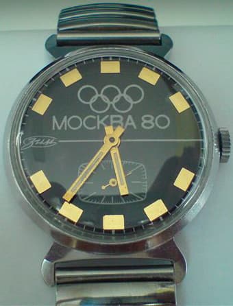 dark black Zim Olympic watch with bright yellow markers and gold hands celebrating the Moscow Olympics in 1980 with a steel case and the olympic rings on the dial