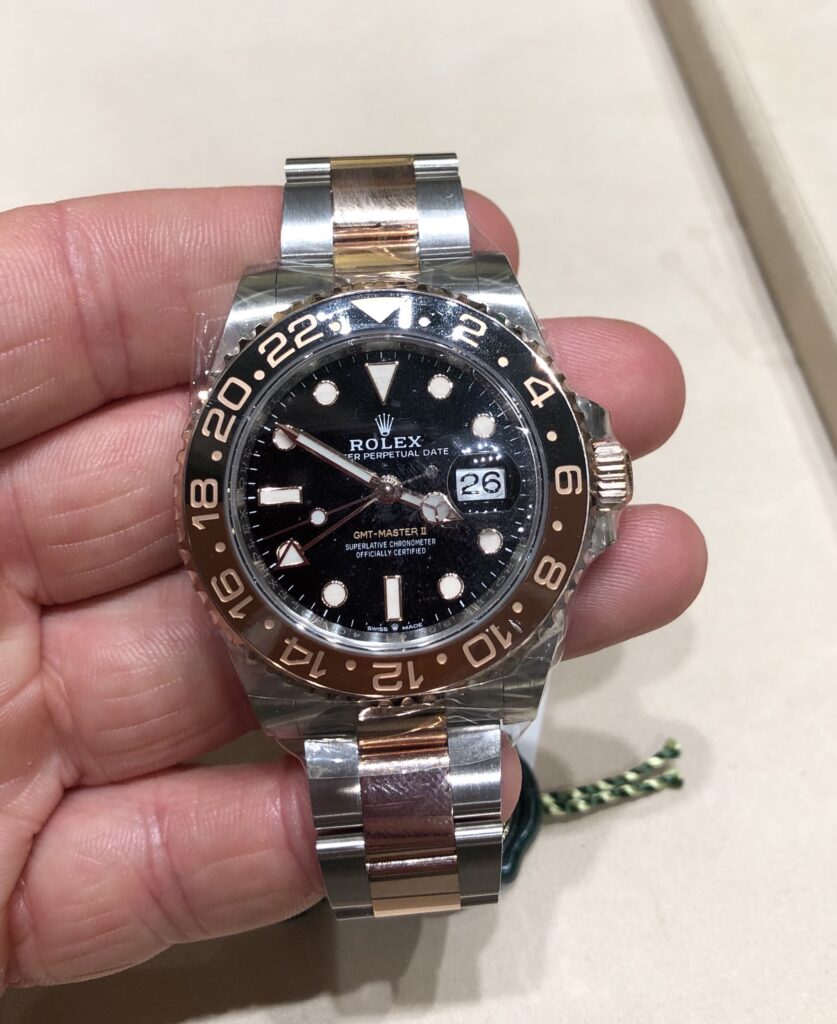 a steel Rolex GMT Master II Rootbeer 126711CHNR with red and blue bezel, black dial