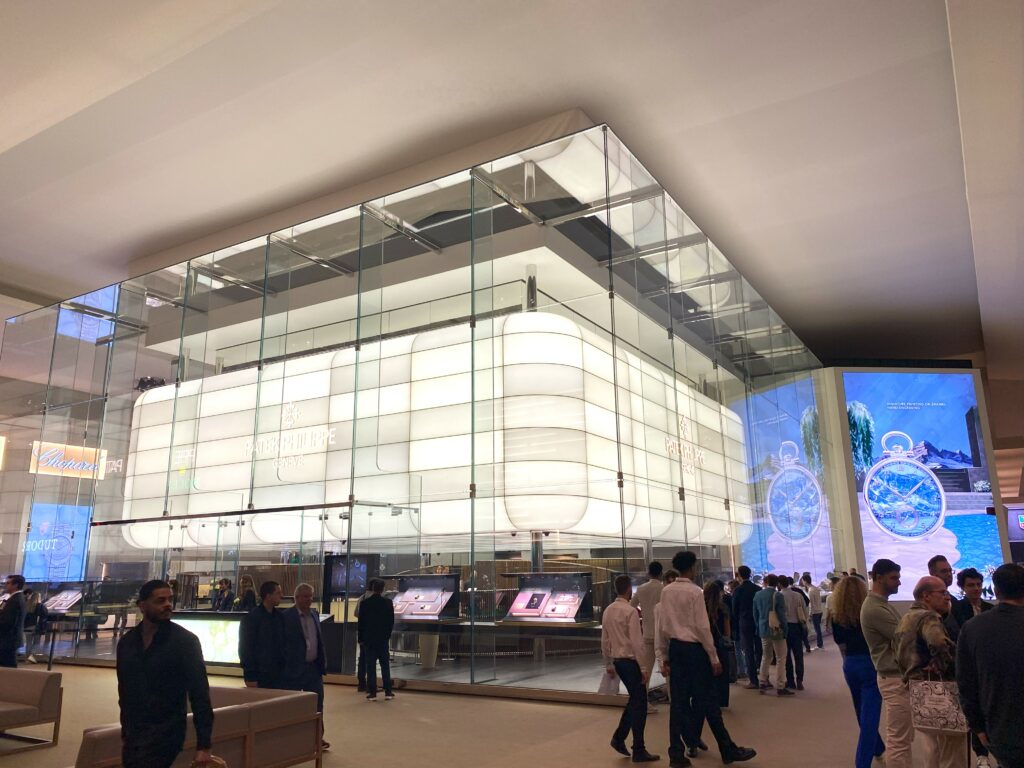 a large bright stand within a huge hall showing the parek philippe logo, with cream walls and ceiling and people milling around the hall